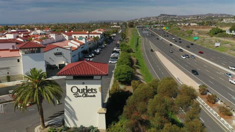 Acercándose-A-La-Vista-Aérea-De-La-Autopista-Cinco-Y-La-Torre-De-Señales-Del-Centro-Comercial-Outlet-San-Clemente,-California