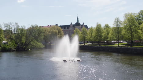 Orbital-shot-of-fountain-in-Motala-ström-canal-river-system-at-Norrköping-Sweden
