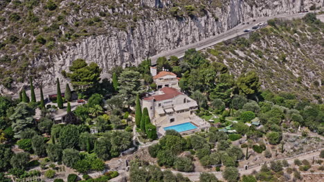 Eze-France-Aerial-v27-breathtaking-birdseye-view-overlooking-at-hillside-mansion-next-to-moyenne-corniche,-pan-reveals-rocky-mountain-cliffs-landscape---July-2021