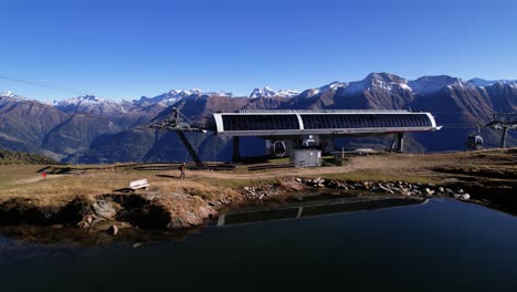 Hiker-walking-to-gondola-station-in-stunning-Swiss-alpine-and-lake-panorama