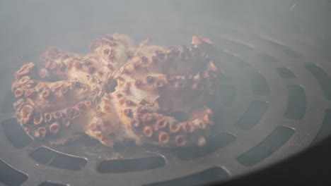 Dramatic-handheld-arc-motion-shot-of-smoked-octopus-with-visible-white-smokes-coming-out-from-the-barbecue-smoker-pit