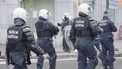Bewaffnete-Polizisten-Gehen-Auf-Die-Straße,-Um-Demonstranten-Gegen-Covid-19-Maßnahmen-In-Brüssel,-Belgien,-Auseinanderzutreiben