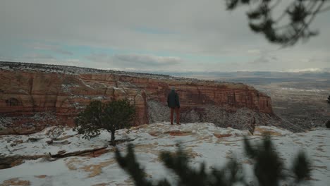 Man-running-in-Snow-Covered-canyon-enjoying-the-beautiful-scenery