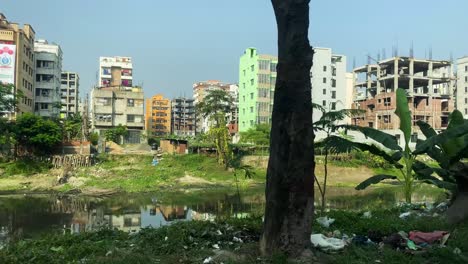 Pov-Viajando-A-Lo-Largo-De-La-Carretera-Al-Lado-Del-Canal-En-Un-área-De-Parcela-Residencial-En-Dhaka