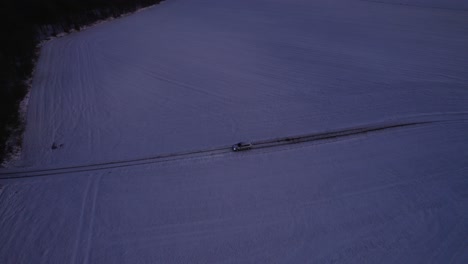 Drone-View-Of-Car-Breaking-Down-On-Snowy-Road-In-The-Middle-Of-Empty-Icy-Field-With-Trees
