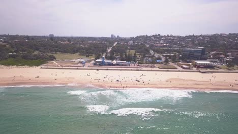 Side-panning-aerial-drone-shot-fly-over-Maroubra-Beach-Sydney,-New-South-Wales-in-a-sunny-day