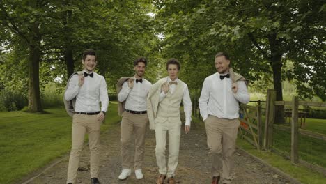 Novio-Con-Caballeros-Caminando-Juntos-En-El-Bosque-A-La-Ceremonia,-Hermoso-Campo-Alrededor-Y-Caminan-Sonriendo-Al-Novio-En-Una-Hermosa-Decoración