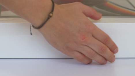 Person's-hands-carrying-new-M1-MacBook-Pro-box-off-white-desk