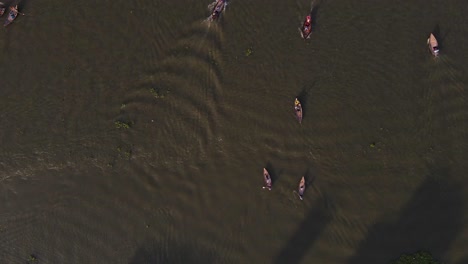 Top-down-view-of-canoes-paddling-on-the-Buriganga-River-in-Bangladesh,-slow-motion