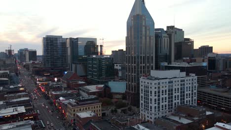 Aerial-view-of-high-rise-and-the-Broadway-street-in-Nashville-city,-USA---circling,-drone-shot