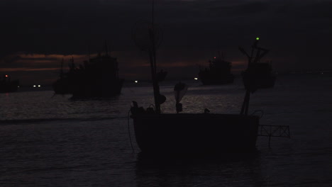 Night-time-view-of-a-beach-in-Vietnam-with-rows-of-boat-with-emergency-light-flashing-on-them.