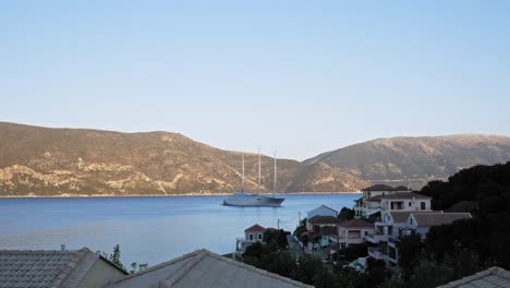 Super-Yacht-Sailing-In-Scenic-Harbor-Village-In-Kefalonia-Greece---wide-shot
