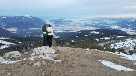 Couple-on-mountain-watching-towards-the-valley