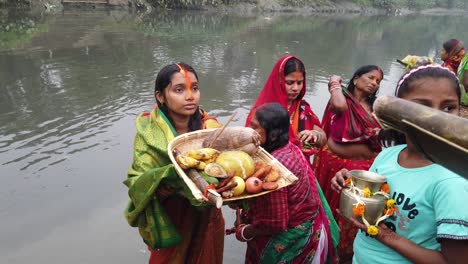 Aufnahme-Einer-Frau,-Die-Puja-Gegenstände-In-Einem-Küchenkorb-Fängt,-Der-Im-Wasser-Des-Ganga-Flusses-Steht,-Für-Eine-Hinduistische-Hochzeitszeremonie