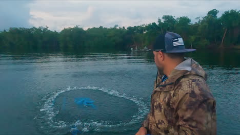 Fisherman-throwing-nest-in-lake-waters,-slow-motion,-handheld,-day