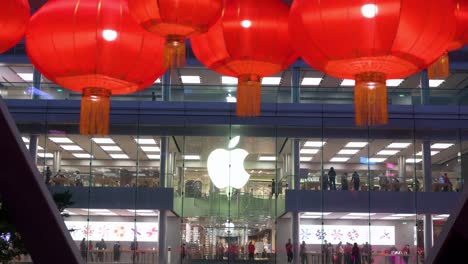 Farolillos-Rojos-Para-El-Año-Nuevo-Lunar-Chino-Cuelgan-De-Un-Puente-Peatonal-Mientras-La-Tienda-Oficial-De-Apple-De-La-Empresa-Multinacional-Estadounidense-De-Tecnología-Se-Ve-Al-Fondo-En-Hong-Kong