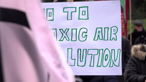 A-handmade-cardboard-placard-is-held-up-that-reads,-“No-to-toxic-air-pollution”-at-a-protest-opposing-a-new-waste-incinerator-at-Edmonton