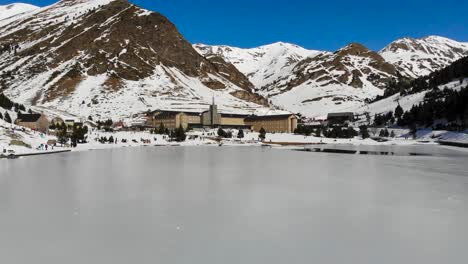 Antena:-Sobrevolando-Un-Lago-Helado-En-El-Valle-Pirenaico-De-Nuria