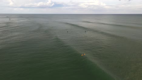Rolling-waves-with-surfers-in-water-on-beach-in-Florida