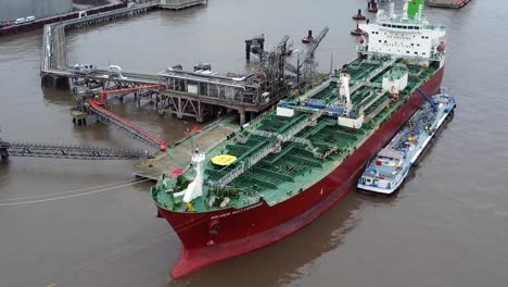 Silver-Rotterdam-oil-petrochemical-shipping-tanker-loading-at-Tranmere-terminal-Liverpool-aerial-view-dolly-left
