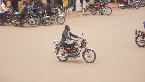 Typisches-Altes-Afrikanisches-Motorrad,-Das-Die-Straße-Entlang-Fährt