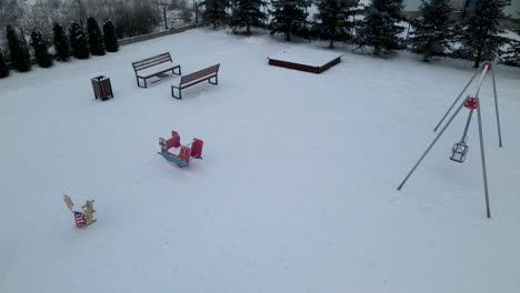 Luftaufnahme-Eines-Schneebedeckten,-Leeren-Spielplatzes-An-Einem-Kalten-Wintertag-In-Polen