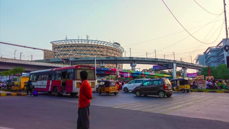 Zeitrafferaufnahme-Der-Wunderschönen-High-Tech-Stadt-Hyderabad-Mit-Einem-Hohen-Gebäude-Vor-Der-Brücke-Und-Den-Menschen-In-Fahrzeugen,-Die-Sich-Auf-Der-Straße-Bewegen