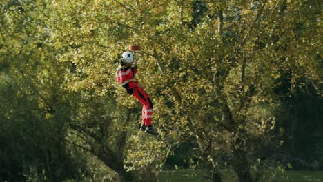 Rescuer-hanging-in-the-air-from-Helicopter-hook-and-landing--sunny-day---slowmotion