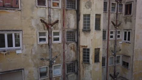 Vista-Detrás-De-Un-Apartamento-Ruinoso-Con-Tuberías-De-Aguas-Residuales-Y-Pintura-Desgastada-En-Las-Paredes-Exteriores-En-Lisboa