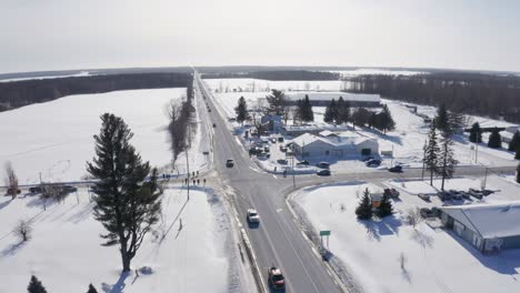 Aerial-reverse-view-shows-supporters-driving-to-hwy-417-from-cornwall-to-support-freedom-convoy-on-cold-sunny-winter-day-in-ontario
