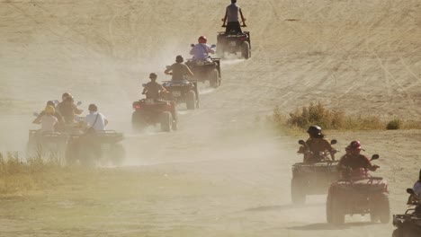 Gruppe-Von-Touristen,-Die-Mit-ATV-Quads-Durch-Die-Wüste-Fahren