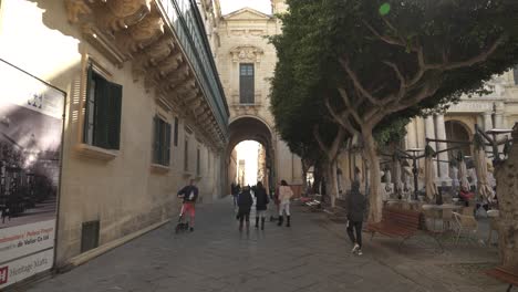 Gente-Disfrutando-De-Un-Día-Soleado-En-La-Ciudad-De-Valletta-Con-árboles-Y-Cafés-Alrededor