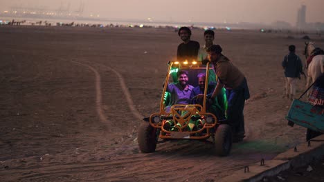 Gruppe-Männlicher-Freunde,-Die-Abends-Einen-Dünenbuggy-Am-Karachi-Strand-Fahren