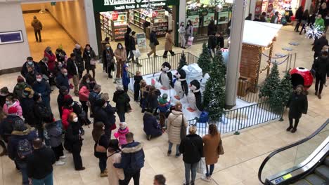 Children-stand-and-listen-to-singing-penguins-in-the-Grand-Arcade-shopping-mall-in-central-Cambridge,-UK