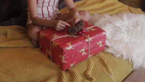 Girl-holds-Christmas-gift-to-open-at-home-Christmas-vacation