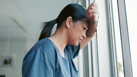 Healthcare-nurse,-stress-and-headache-by-window
