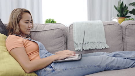Search,-laptop-and-relax-with-woman-on-sofa