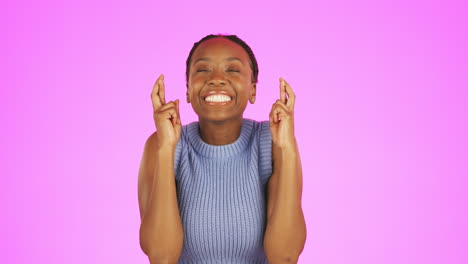 Black-woman,-fingers-crossed-and-smile-in-studio