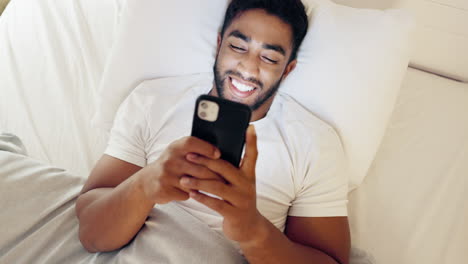 Happy-man,-phone-and-lying-on-bed-for-social