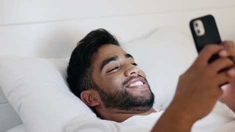 Man,-phone-and-smile-lying-in-bed-for-social
