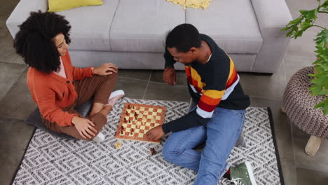 Chess,-game-and-couple-on-floor-in-home-playing