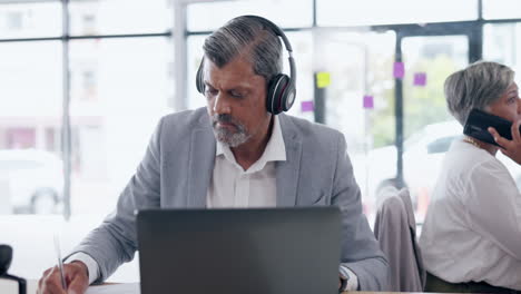 Headphones,-laptop-and-business-man-writing