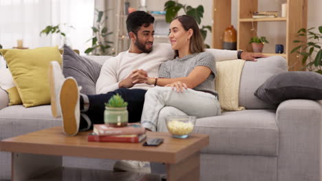 Couple,-kiss-and-holding-hands-on-home-sofa
