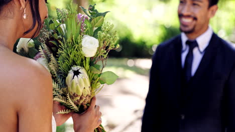 Glücklicher-Bräutigam,-Der-Der-Braut-Einen-Blumenstrauß-Im-Park-Schenkt