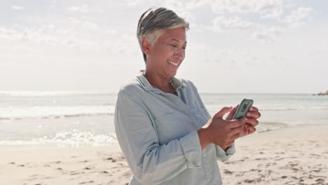 Beach,-texting-and-happy-elderly-woman-laughing