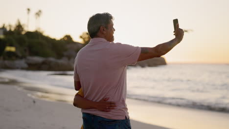 Couple-and-beach-selfie-on-sunset-walk