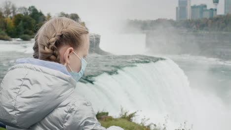 Ein-Kind-Mit-Schutzmaske-Bewundert-Die-Niagarafälle.-Reisen-Während-Der-Pandemie