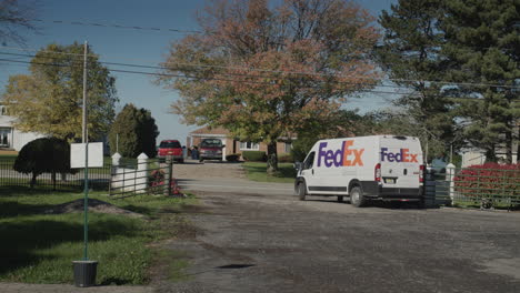 Wilson,-NY,-USA,-October-2021:-The-Fedex-postal-service-car-leaves-the-yard-after-the-parcel-has-been-delivered
