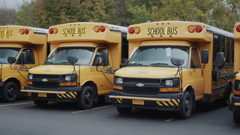 Wilson,-Nueva-York,-Estados-Unidos,-Octubre-De-2021:-Fila-De-Autobuses-Escolares-Amarillos-En-El-Estacionamiento-Cerca-De-La-Escuela