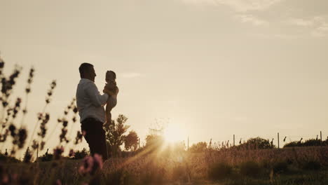Happy-man-throws-his-daughter-up-in-the-rays-of-the-setting-sun